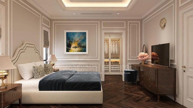 Trang trí nội thất phòng ngủ tân cổ điển nhẹ nhàng, sang trọng với giường bọc nệm trắng, kệ tivi gỗ óc chó cao cấp.